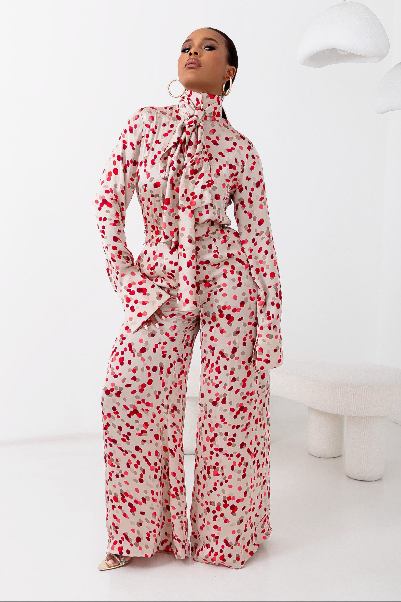 A stylish silk matching set made of premium luxe silk with red polka dot patterns for a chic and luxury look. Styled with gold hoop earrings.