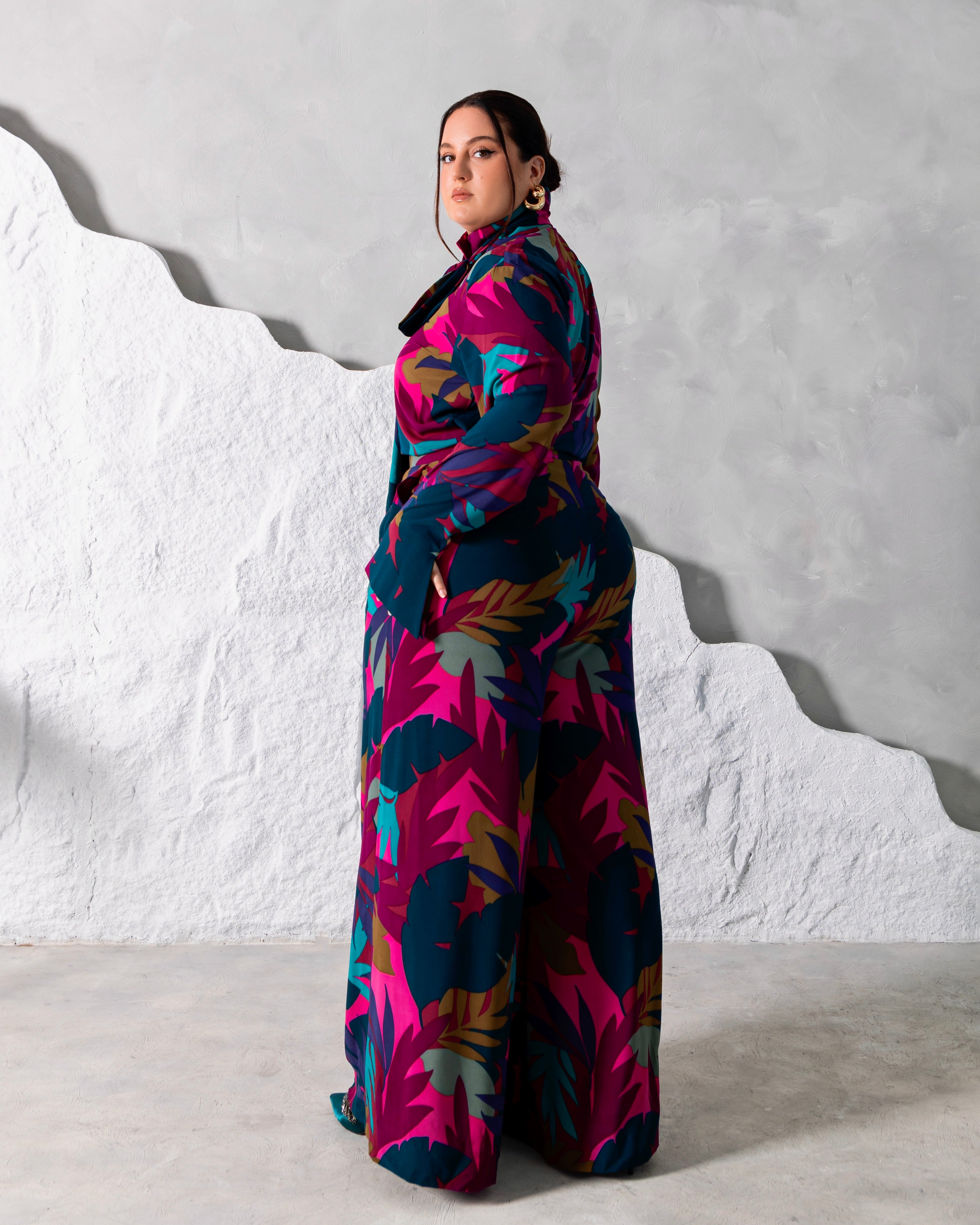 Side view of the sophisticated printed coord set featuring a high neck long-sleeve blouse with neck tie, and a high waist palazzo pants to match.