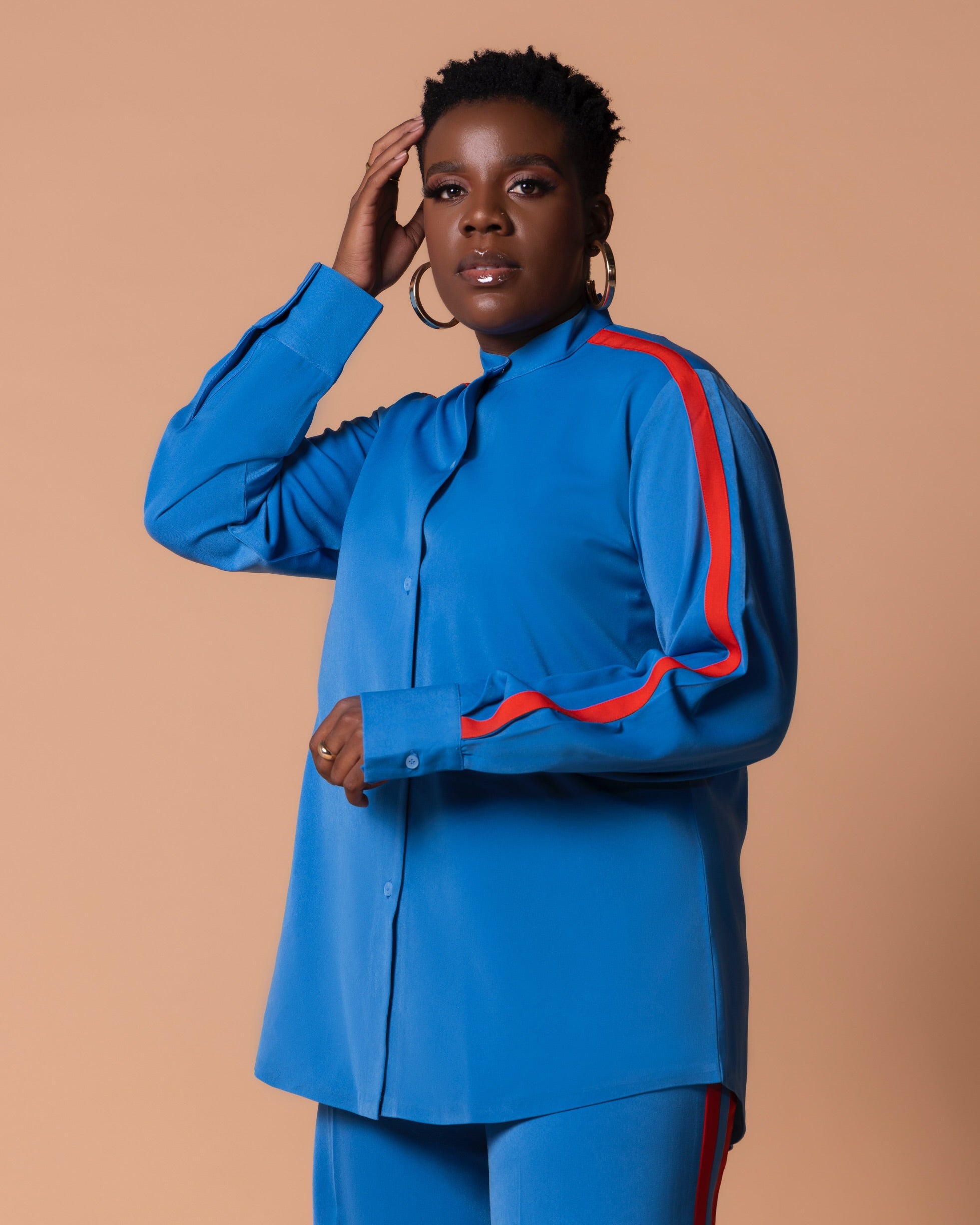 Close-up of Maison Set Azure showing bishop neck shirt, contrast stripe sleeve detail and matching high-waist striped straight-leg trousers.