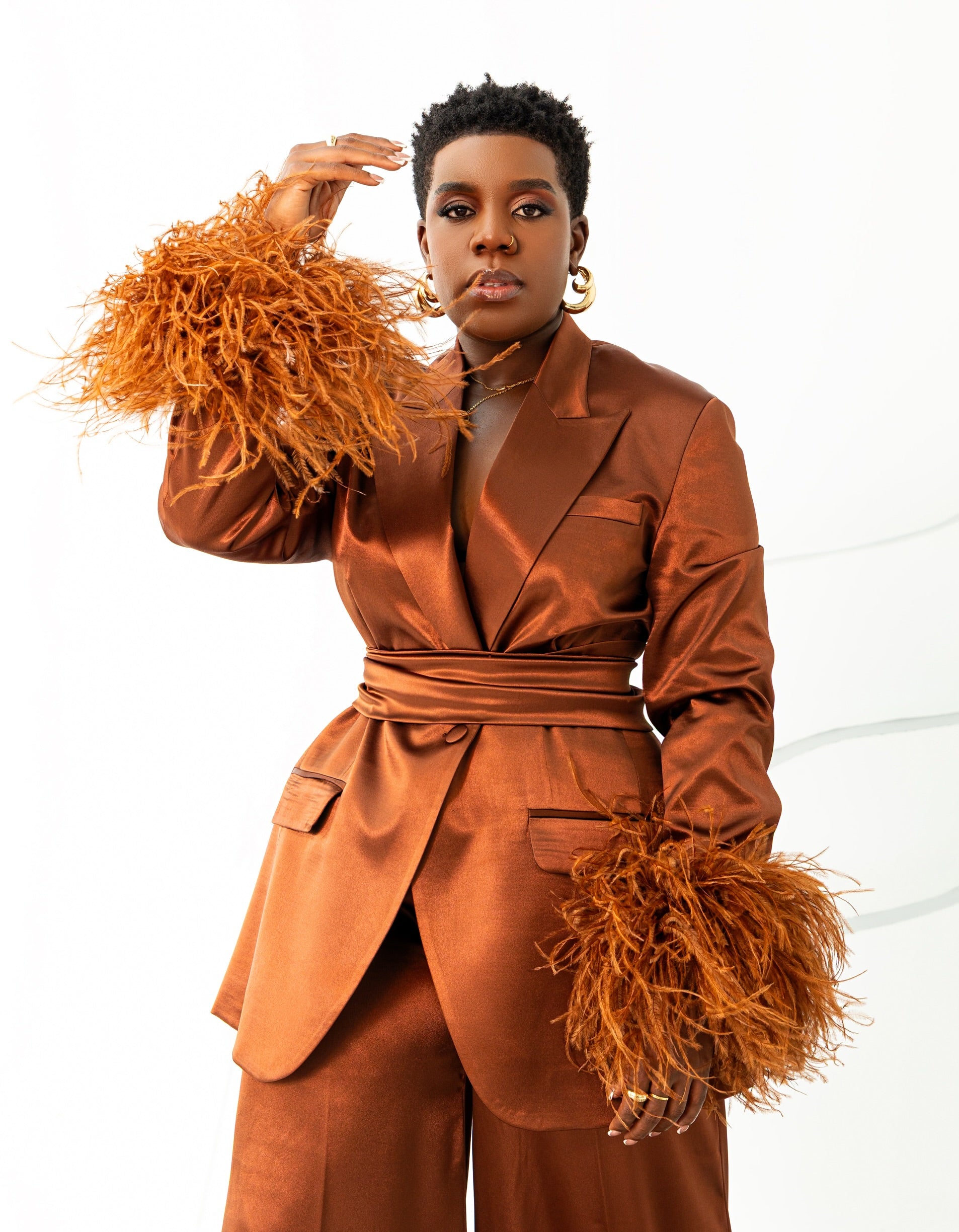 Model wearing Olarsgrace’s Taylor satin-silk suit set with feathered sleeves, belted blazer, and wide-leg pants in bronze.