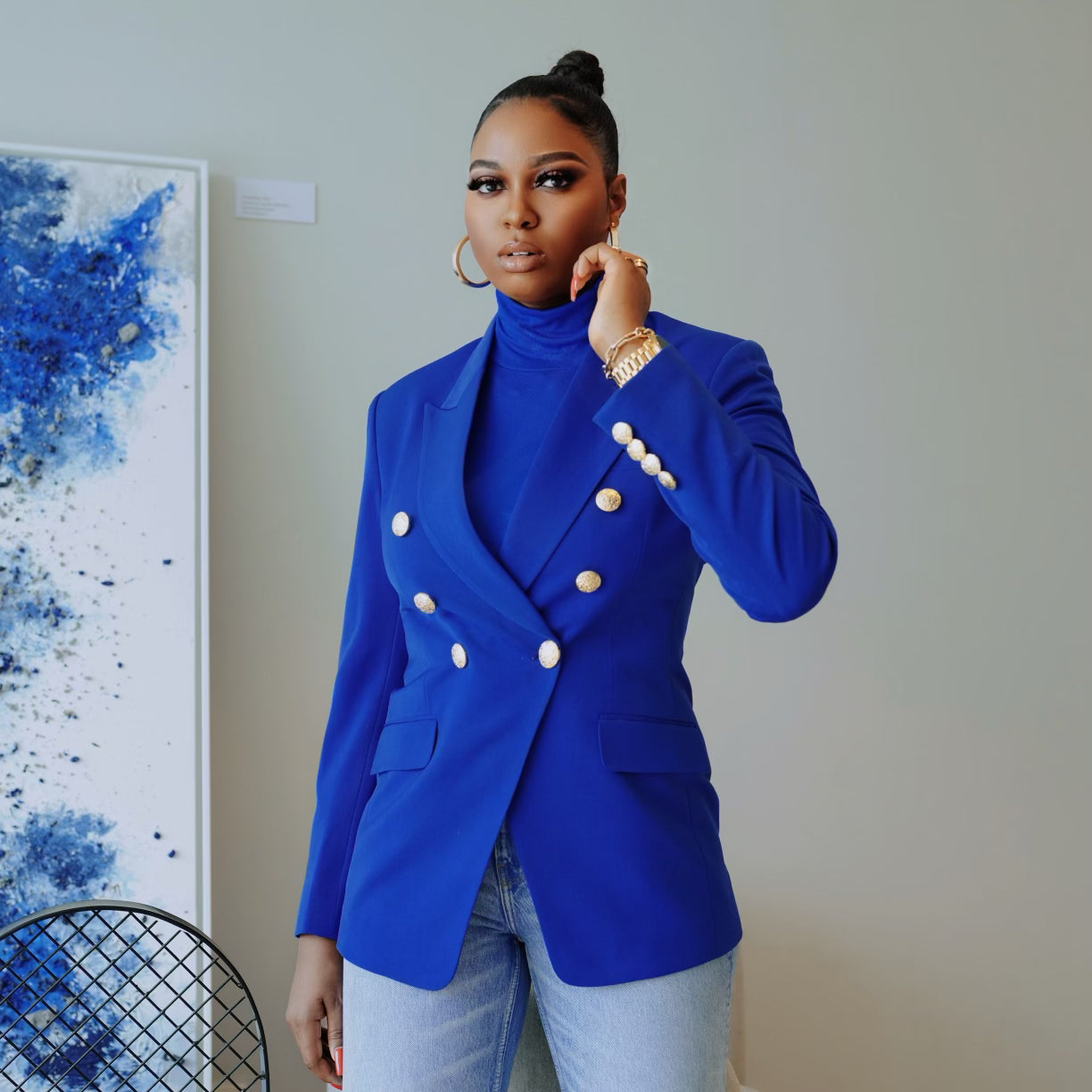 Model in a structured cobalt blue double-breasted blazer with gold buttons, paired with jeans.