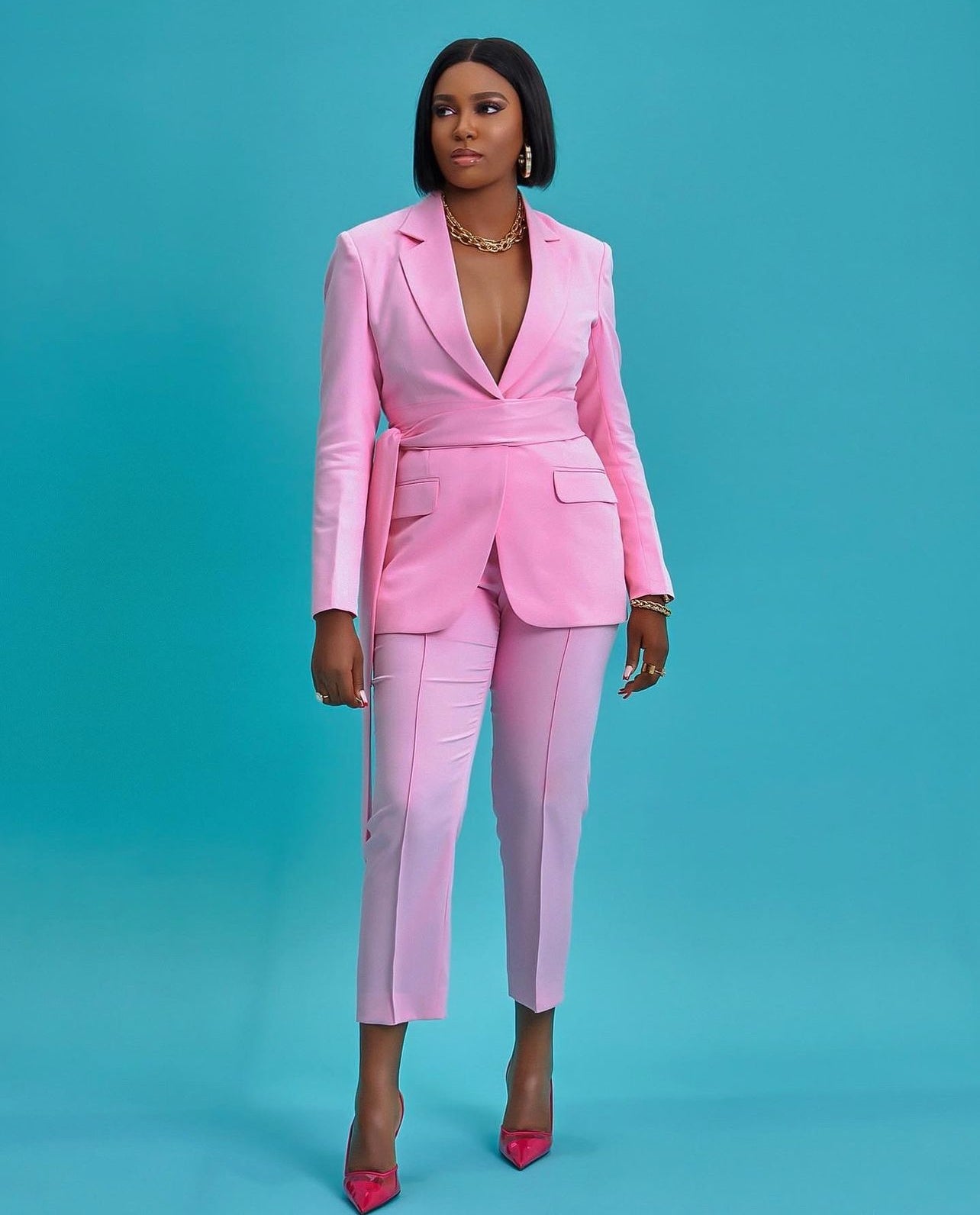 Delores pink belted blazer with lapels and flap pockets, styled with matching high-waist ankle pants.