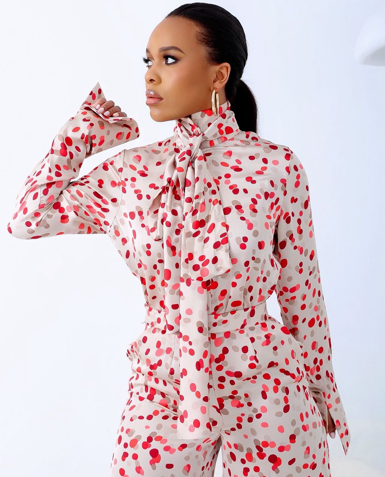 Close-up of Faith Polka Dot Set consisting of high-neck-tie detail and wide-leg pants made of soft premium silk with red polka dots.