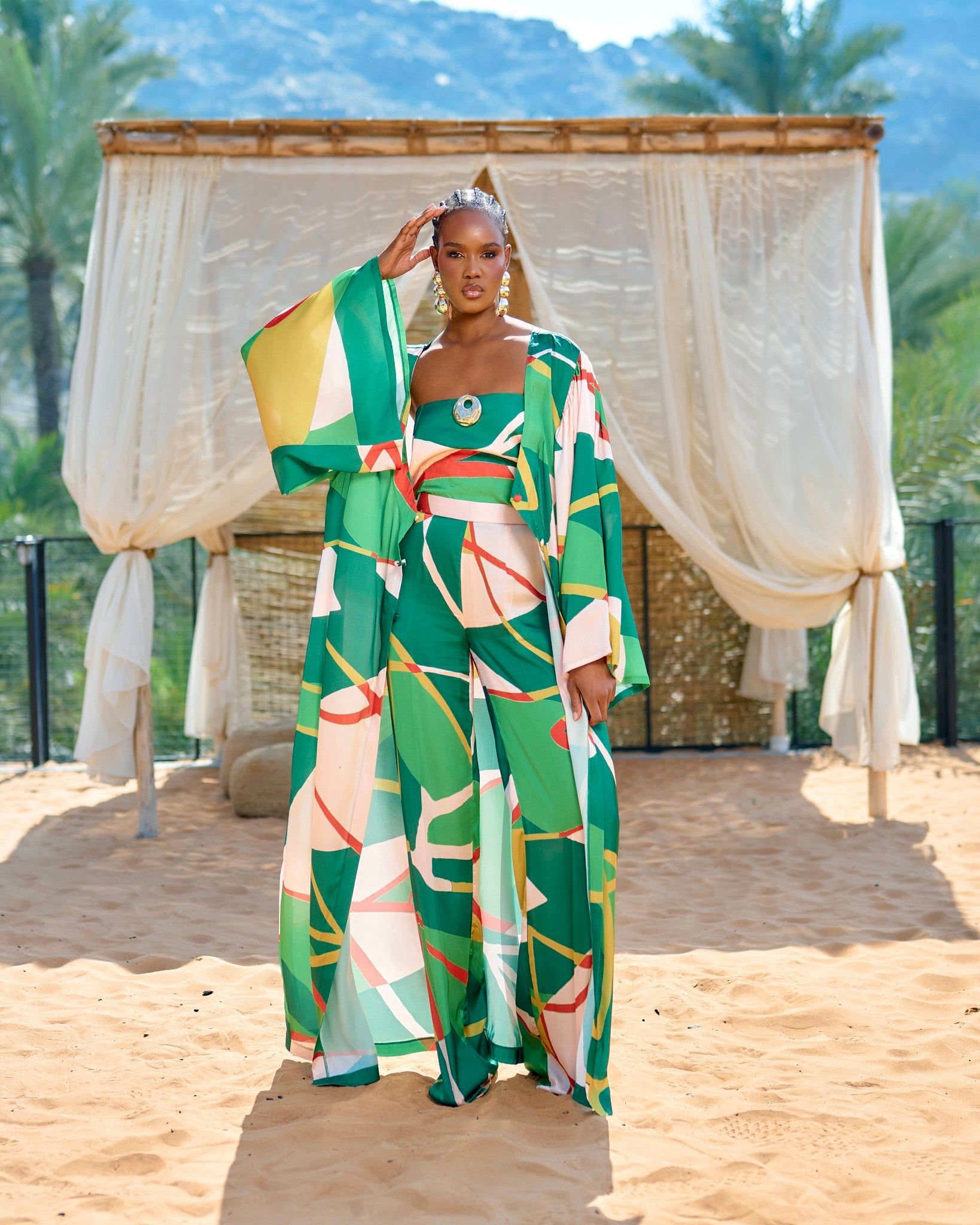 Kimono cover up in green printed fabric flowing maxi silhouette with wide sleeves and abstract print viewed from the back.