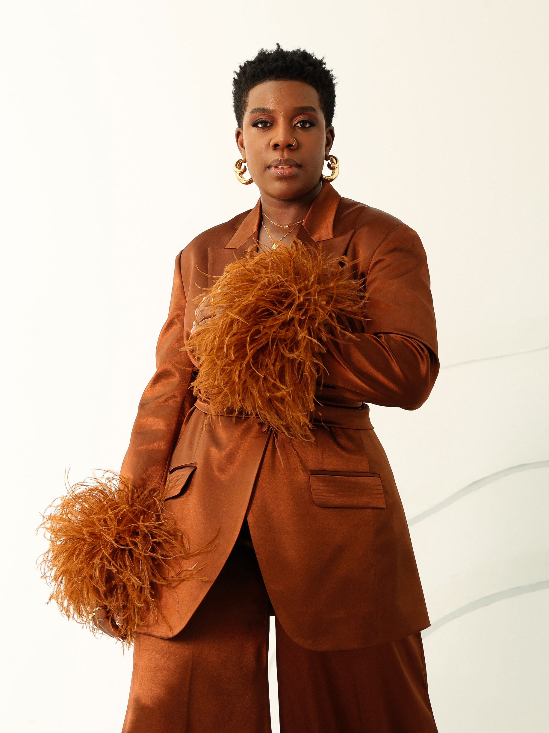 Model wearing Olarsgrace’s Taylor satin-silk suit set with feathered sleeves, belted blazer, and wide-leg pants in luxe bronze colour.