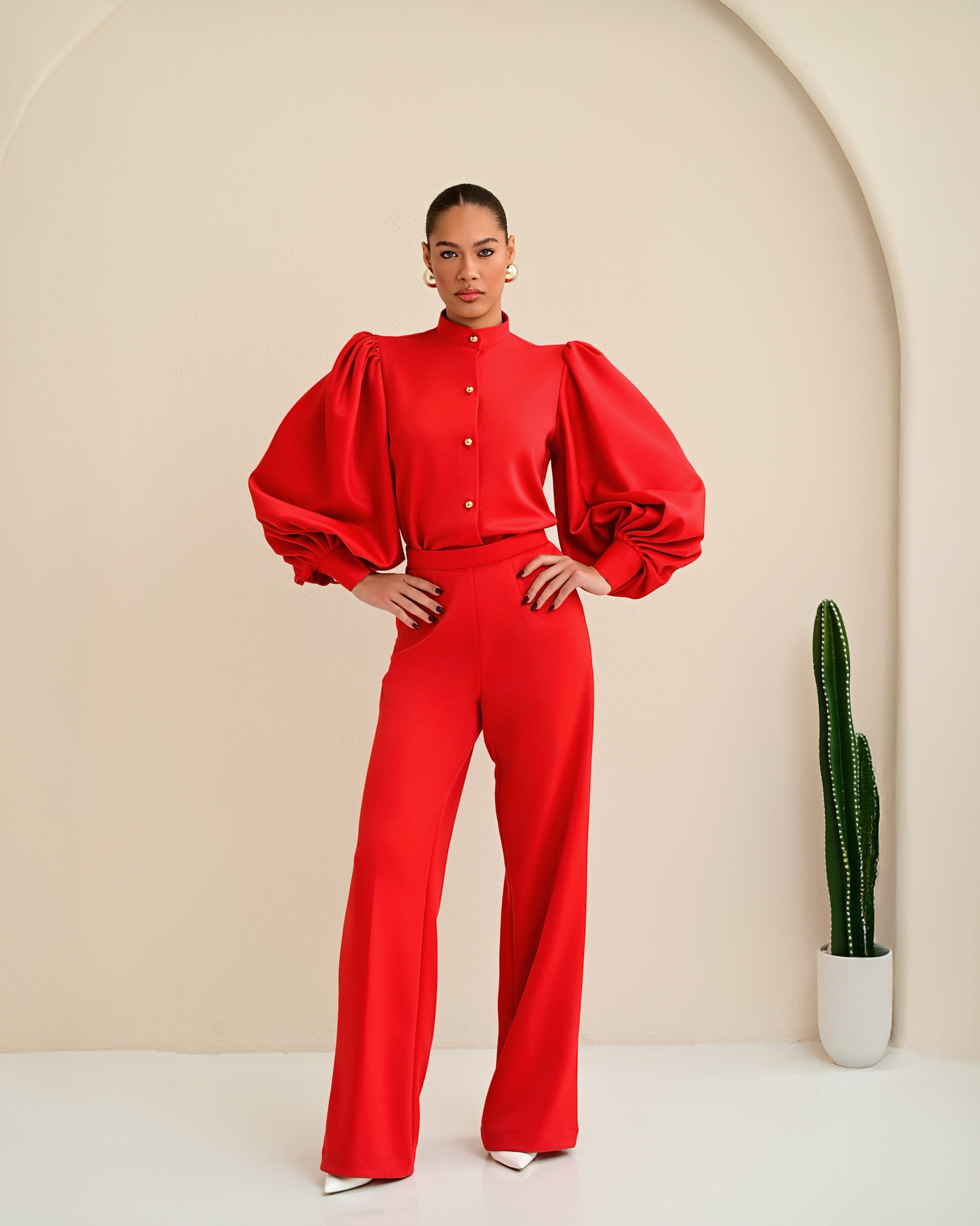 Model wearing Shabir Set in red featuring bishop collar button top with exaggerated balloon sleeves and matching straight-leg pants, full-length front view.