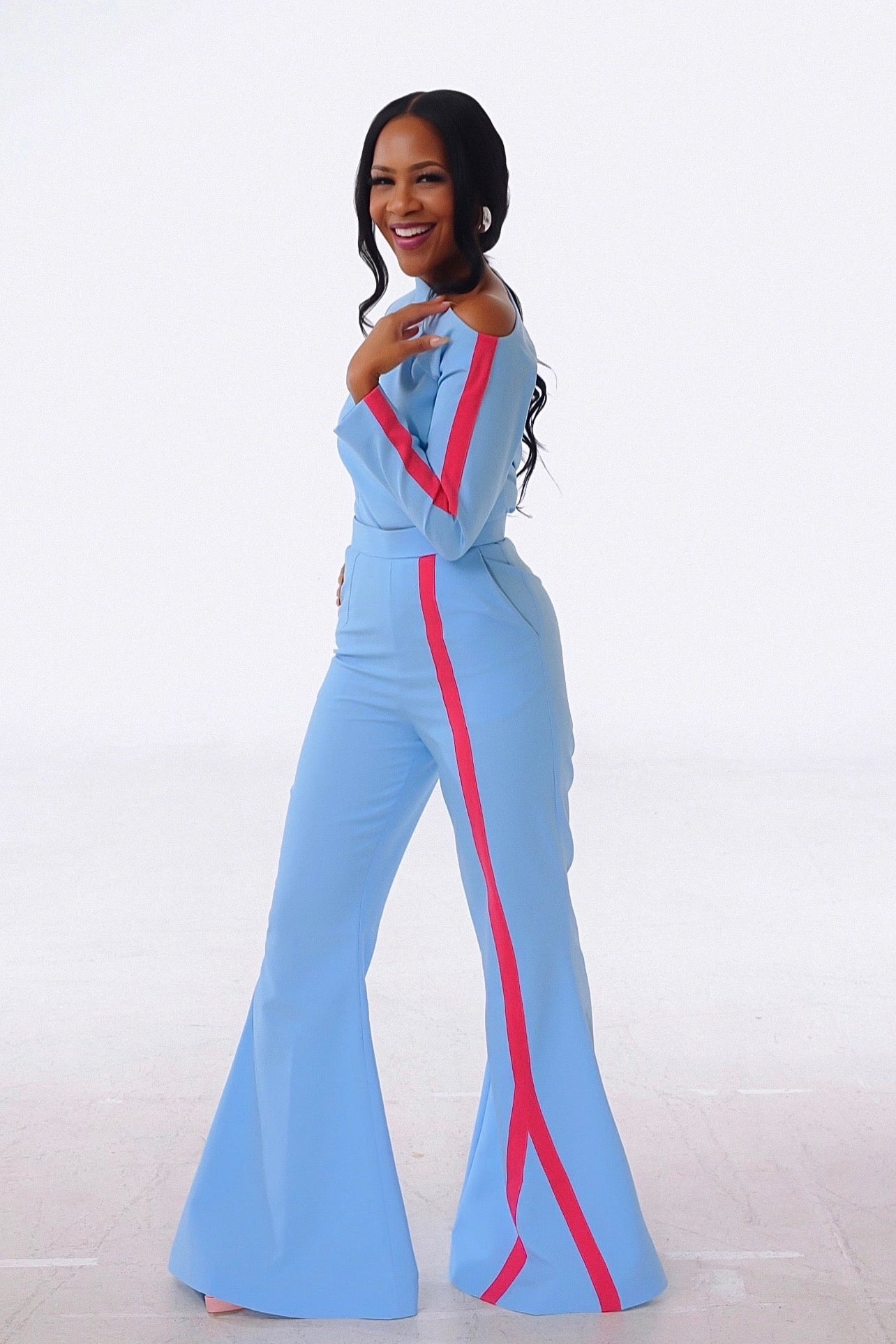 Side view of an stylish olarsgrace Sky blue off-shoulder top with pink stripe detailing paired with matching flared trousers.