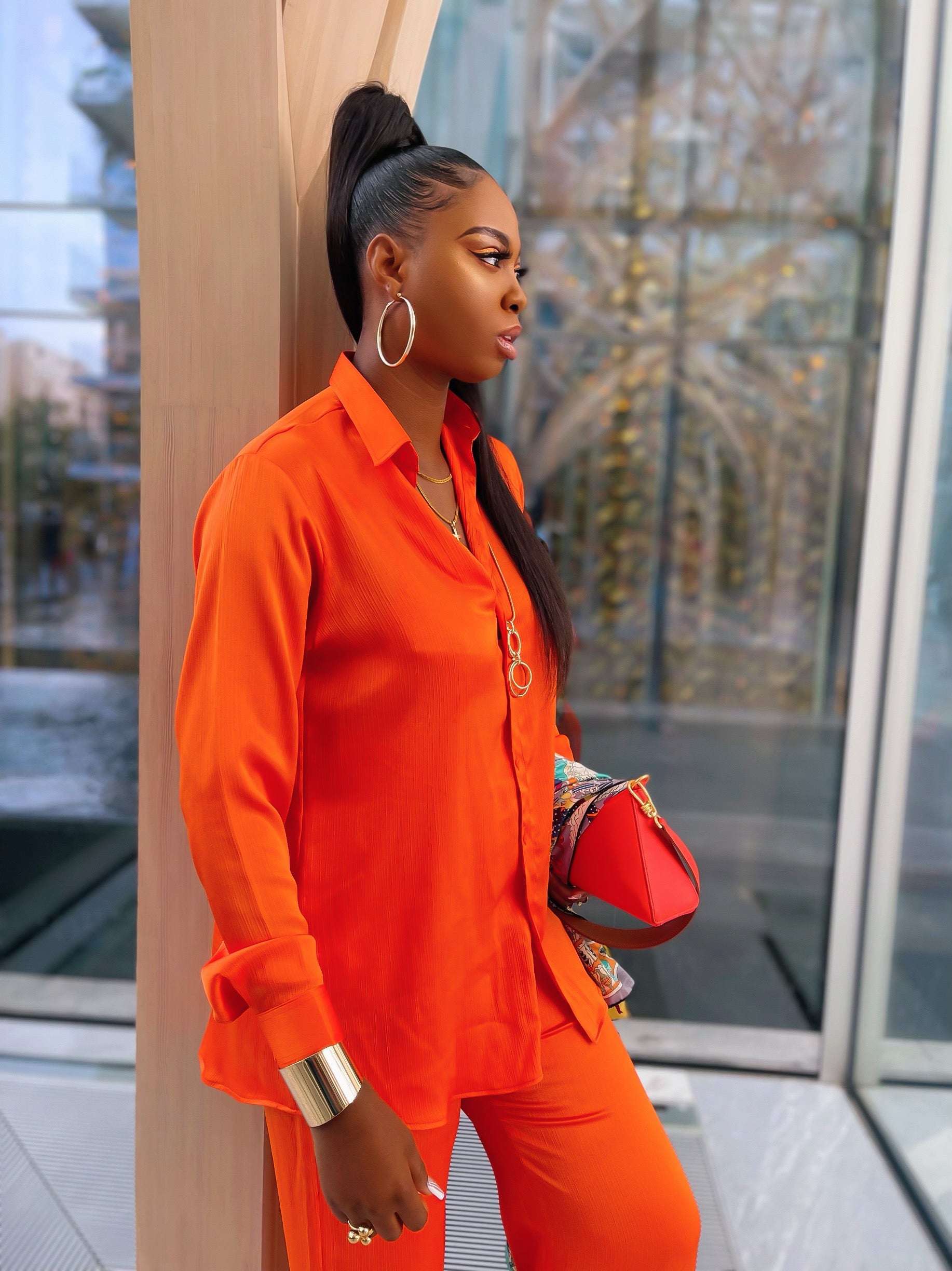 A side-profile view of olarsgrace Orange co-ord outfit with relaxed cuffed button shirt and matching high-waist straight-leg trousers.