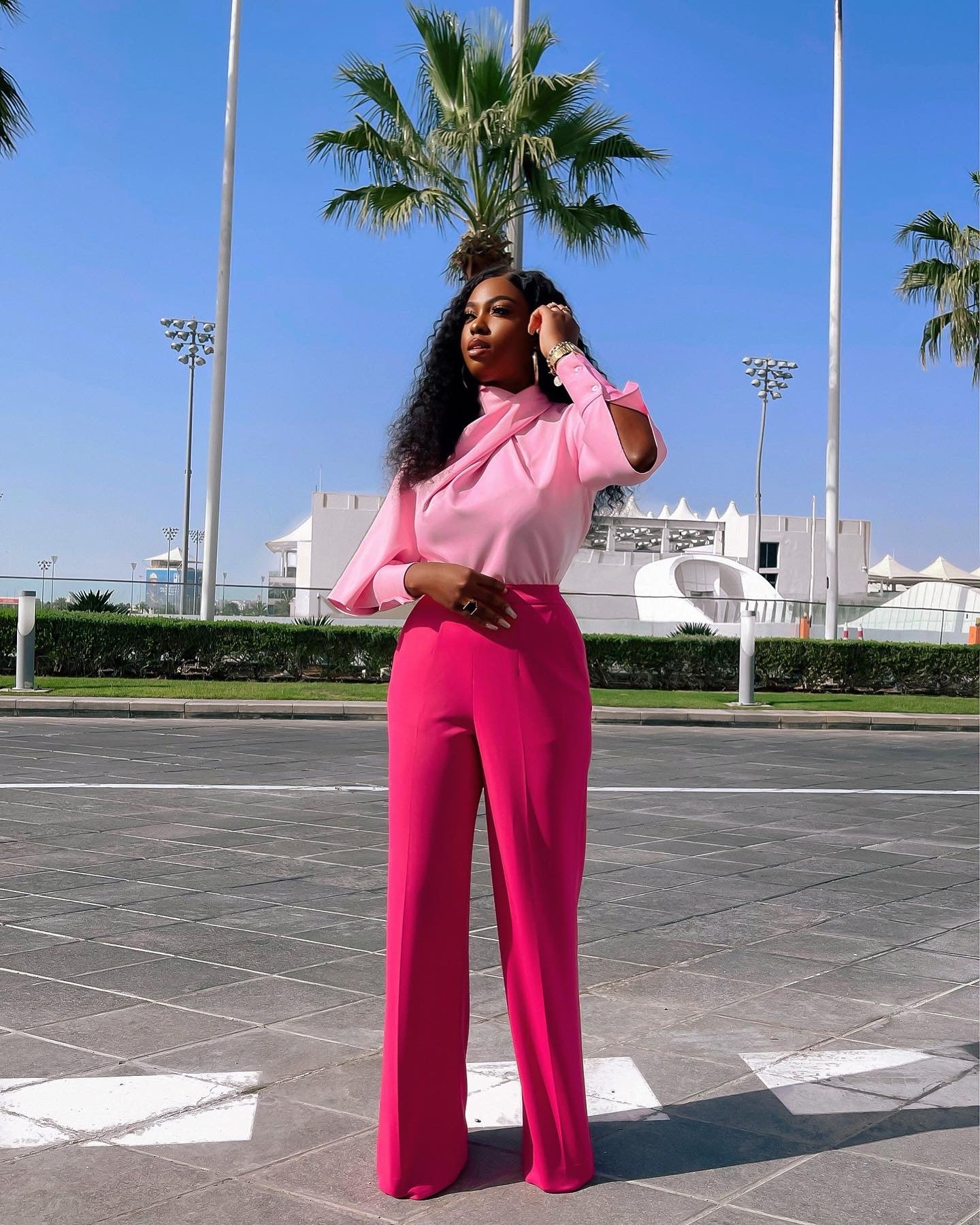 Full-length view of the Olarsgrace Najma Set. Featuring a pink high-neck drape blouse with cuff slits and fuchsia high-waist straight-leg pants